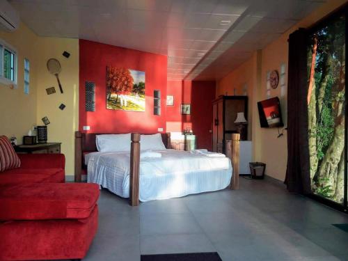 a bedroom with a bed and a red wall at LLamados Fishing Lake in San Kamphaeng