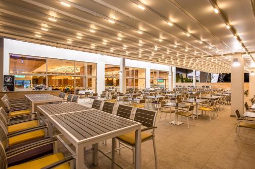 Hotel Nais في نيشْ: غرفة طعام مع طاولات وكراسي في مبنى
