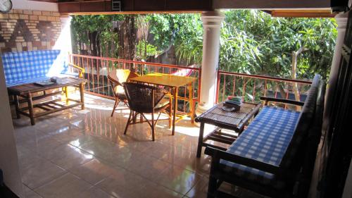 a porch with a table and chairs on a balcony at Horas Family Home in Tuk Tuk