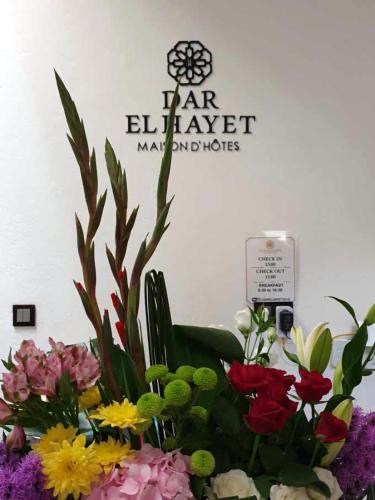 a bouquet of flowers in front of a sign at Dar El Hayet in Tangier