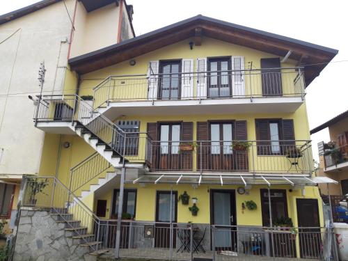 une maison jaune avec des balcons et des escaliers dans l'établissement Casetta Gialla, à Giaveno