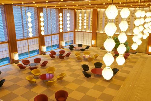 a large room with tables and chairs and windows at The Okura Tokyo in Tokyo