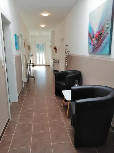 a waiting room with black chairs and a tile floor at Ferienwohnung Semler in Puchberg am Schneeberg