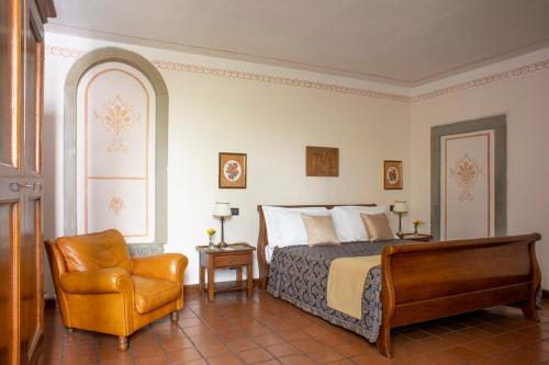 a bedroom with a bed and a chair at B&B Le Cannelle FIESOLE in Fiesole
