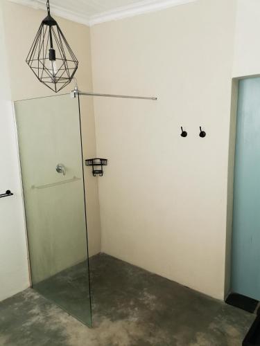 a room with a shower and a glass door at MacNut Bed and Breakfast in Nelspruit