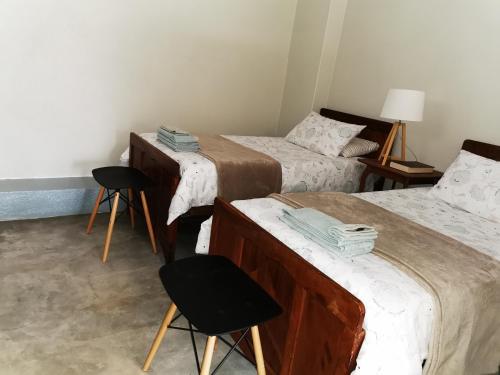 a room with two beds and two chairs in it at MacNut Bed and Breakfast in Nelspruit