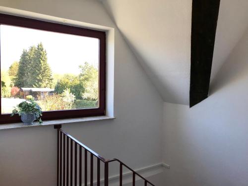 - un escalier avec une grande fenêtre dans une maison dans l'établissement MAL Steinbock _ Ferienwohnung Anni, à Malente