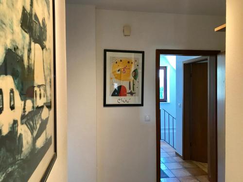 un couloir avec une peinture sur le mur et une photo dans l'établissement MAL Steinbock _ Ferienwohnung Anni, à Malente