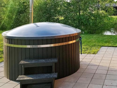 a jacuzzi tub with a pair of stairs in a yard at 8 person holiday home in Glesborg in Glesborg
