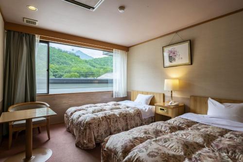 Postel nebo postele na pokoji v ubytování Kurobe View Hotel