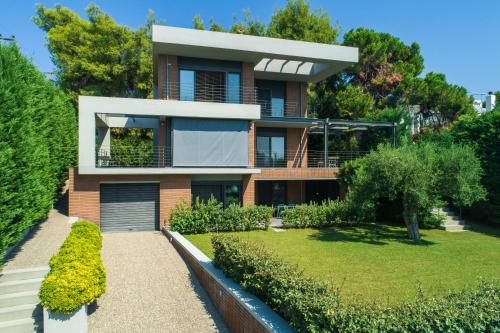 a house with a garden in front of it at Elia Seafront Villa in Elia