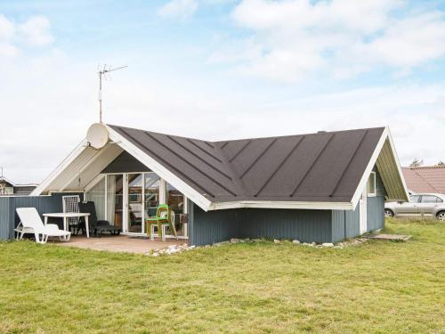 a house with a pitched roof with a patio at 5 person holiday home in Harbo re in Harboør