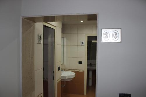 La salle de bains est pourvue d'un lavabo et de toilettes. dans l'établissement Luander Hotel, à Tirana