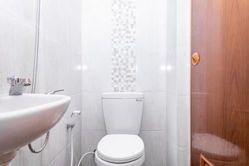 a white bathroom with a toilet and a sink at RedDoorz near Alun Alun Bandung 2 in Bandung