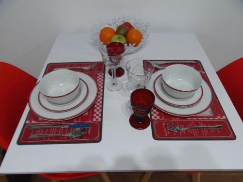 a table with two red trays with plates and glasses at Apartamento en Triana in Seville