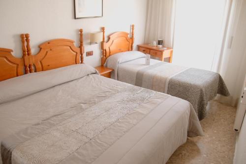 a bedroom with two beds and a window at Hostal La Toba in Cañete