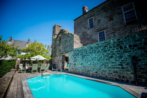 a swimming pool in front of a building at Great House - Grand Georgian House With Outdoor Heated Pool in Laugharne