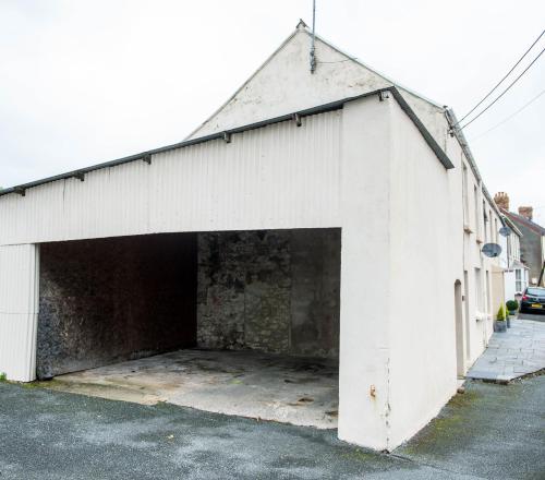 a large white building with a large garage at Awel Taf- Central cottage ideal for families, with parking in St Clears