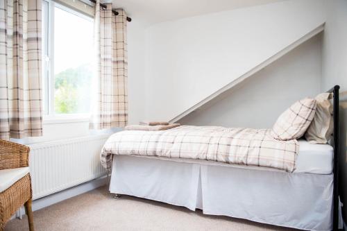 a bedroom with a bed and a window at Awel Taf- Central cottage ideal for families, with parking in St Clears