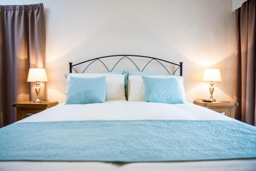 a bedroom with a blue and white bed with two lamps at Awel Taf- Central cottage ideal for families, with parking in St Clears