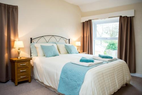 a bedroom with a large bed and a window at Awel Taf- Central cottage ideal for families, with parking in St Clears
