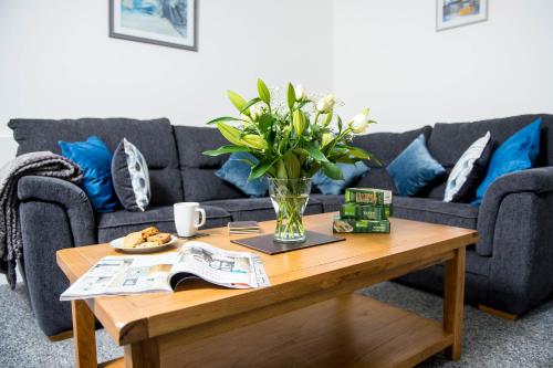 a living room with a couch and a coffee table at Awel Taf- Central cottage ideal for families, with parking in St Clears