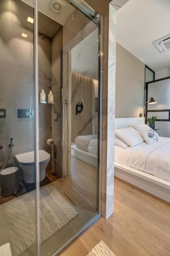 a bathroom with a glass door leading to a bed and a tub at Arveskida Suite Apartment in Cagliari