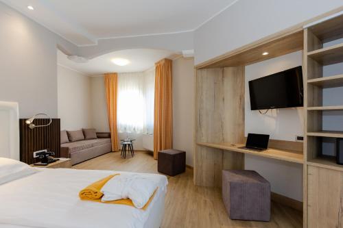 um quarto de hotel com uma cama e uma televisão de ecrã plano em Hotel Terme Leonardo em Abano Terme