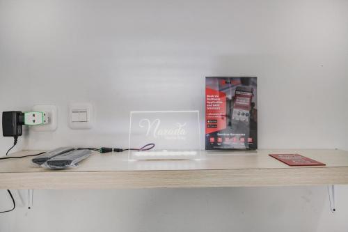 a table with a laptop and a book on it at RedDoorz @ Jalan Narada Lampung in Bandar Lampung