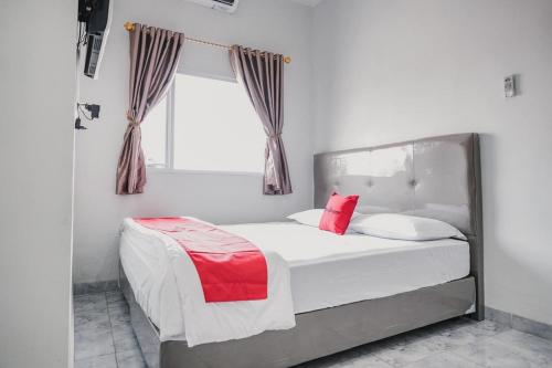a bedroom with a bed with red and white pillows at RedDoorz @ Jalan Narada Lampung in Bandar Lampung