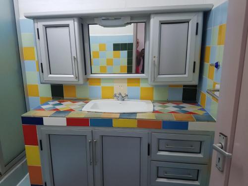 a bathroom with a sink and a colorful counter top at Lapiroguevilla (Tourist resident licence 03596) in Pereybere