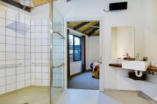 W łazience znajduje się prysznic, umywalka i lustro. w obiekcie Karma Kinglake w mieście Kings Lake East