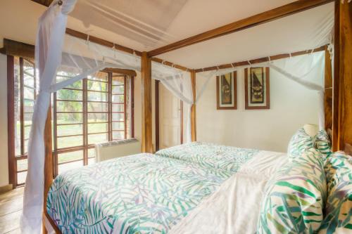 a bedroom with a bed and a window at Vila Do Paraiso in Vilanculos
