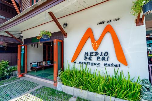 a restaurant with a sign on the side of a building at Medio De Pai in Pai