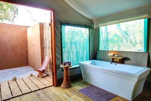 a bathroom with a large tub and a shower at Fathala Wildlife Reserve in Toubakouta
