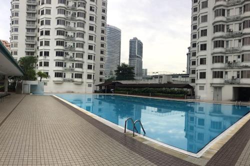 ein Schwimmbad in der Mitte von zwei hohen Gebäuden in der Unterkunft Cozy Kelana Jaya Semi-D Apt near Mall, College & Hospital in Petaling Jaya