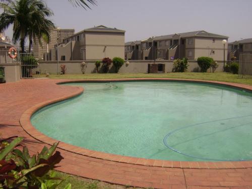 - une grande piscine dans une cour avec des bâtiments dans l'établissement North Beach Durban Apartments, à Durban