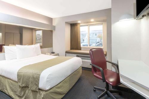 亨利耶塔的住宿－溫德姆亨麗埃塔微型酒店，酒店客房配有一张床、一张桌子和一把椅子。