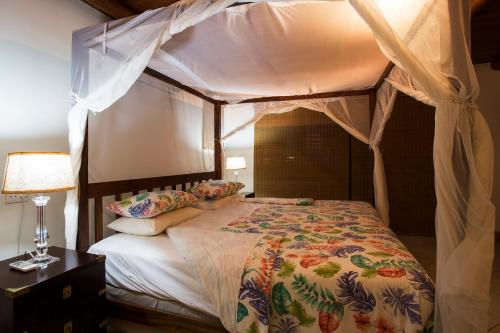 a bedroom with a bed with a canopy at Vila Do Paraiso in Vilanculos