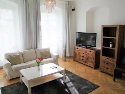 a living room with a couch and a tv at Charles Bridge Apartments in Prague