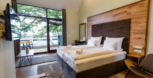 a bedroom with a large bed and a large window at Panorama Hotel & Spa in Kruševo