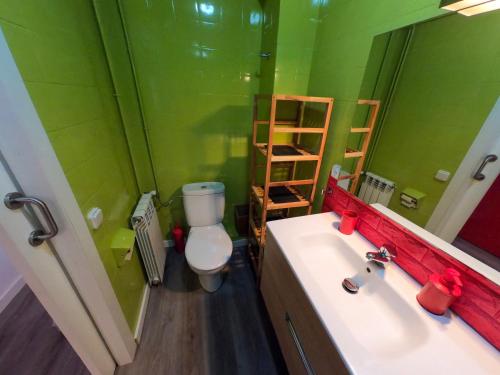 ein grünes Bad mit einem WC und einem Waschbecken in der Unterkunft Piso luminoso y moderno a un minuto del río (Sort) in Sort