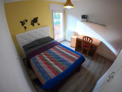 Schlafzimmer mit einem Bett, einem Schreibtisch und einem Stuhl in der Unterkunft Piso luminoso y moderno a un minuto del río (Sort) in Sort
