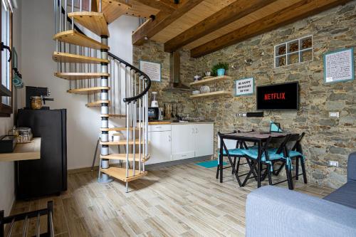 a kitchen and dining room with a spiral staircase and a table at Villa Margherita Ecolodge in Crespino