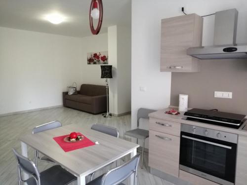 eine Küche und ein Wohnzimmer mit einem Tisch und Stühlen in der Unterkunft ALEXA casa vacanze in Pero