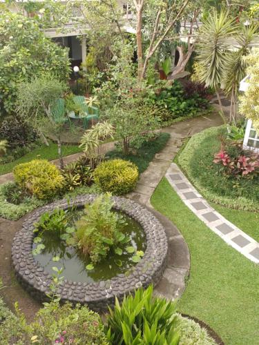 a garden with a pond with plants and trees at Hotel Bumi Asih Gedung Sate Bandung in Bandung