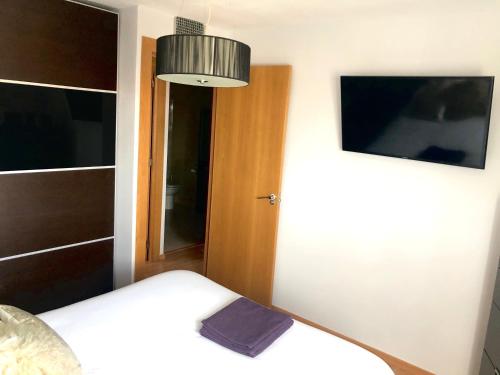 Dormitorio pequeño con cama y lámpara en Piso semicentrico con vistas a la bahía de Algeciras en Algeciras