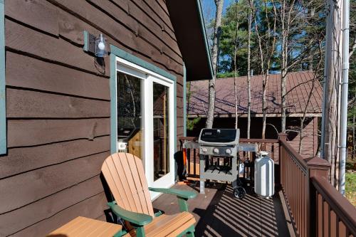 um pátio com duas cadeiras e um grelhador numa casa em Cobble Mountain Lodge em Lake Placid