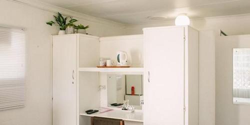 a white bathroom with a sink and a mirror at Pennylane Guest House in Ermelo