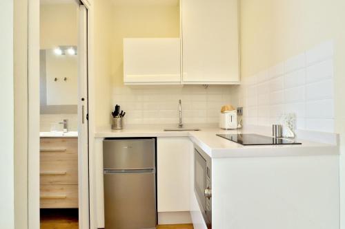 a kitchen with white cabinets and a stainless steel dishwasher at Hacienda El Brillante in Córdoba